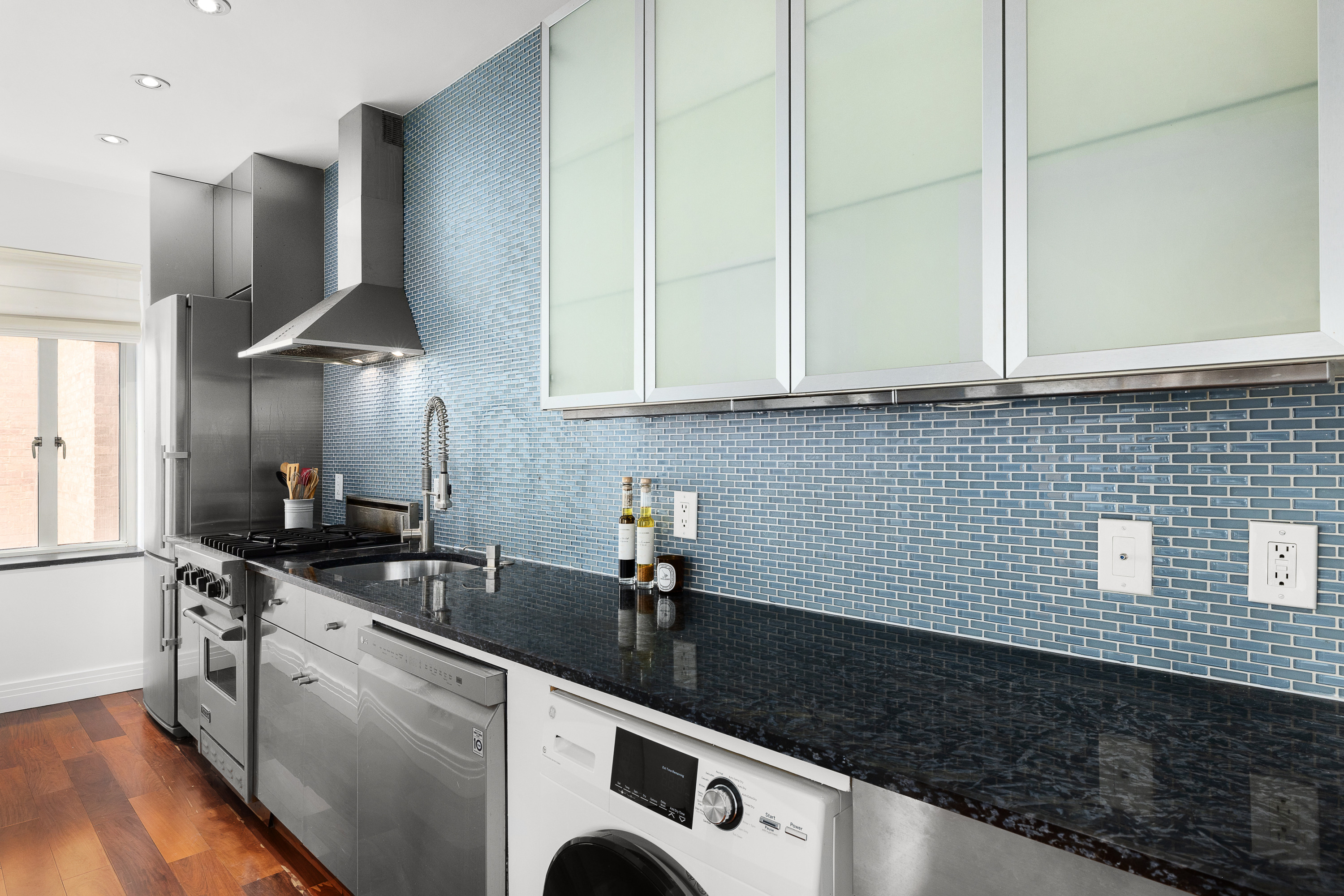 165 West 20th Street, Unit 3L Manhattan, NY 10011 - Photo 3 of 7 a kitchen with stainless steel appliances granite countertop a sink a stove and a wooden floors