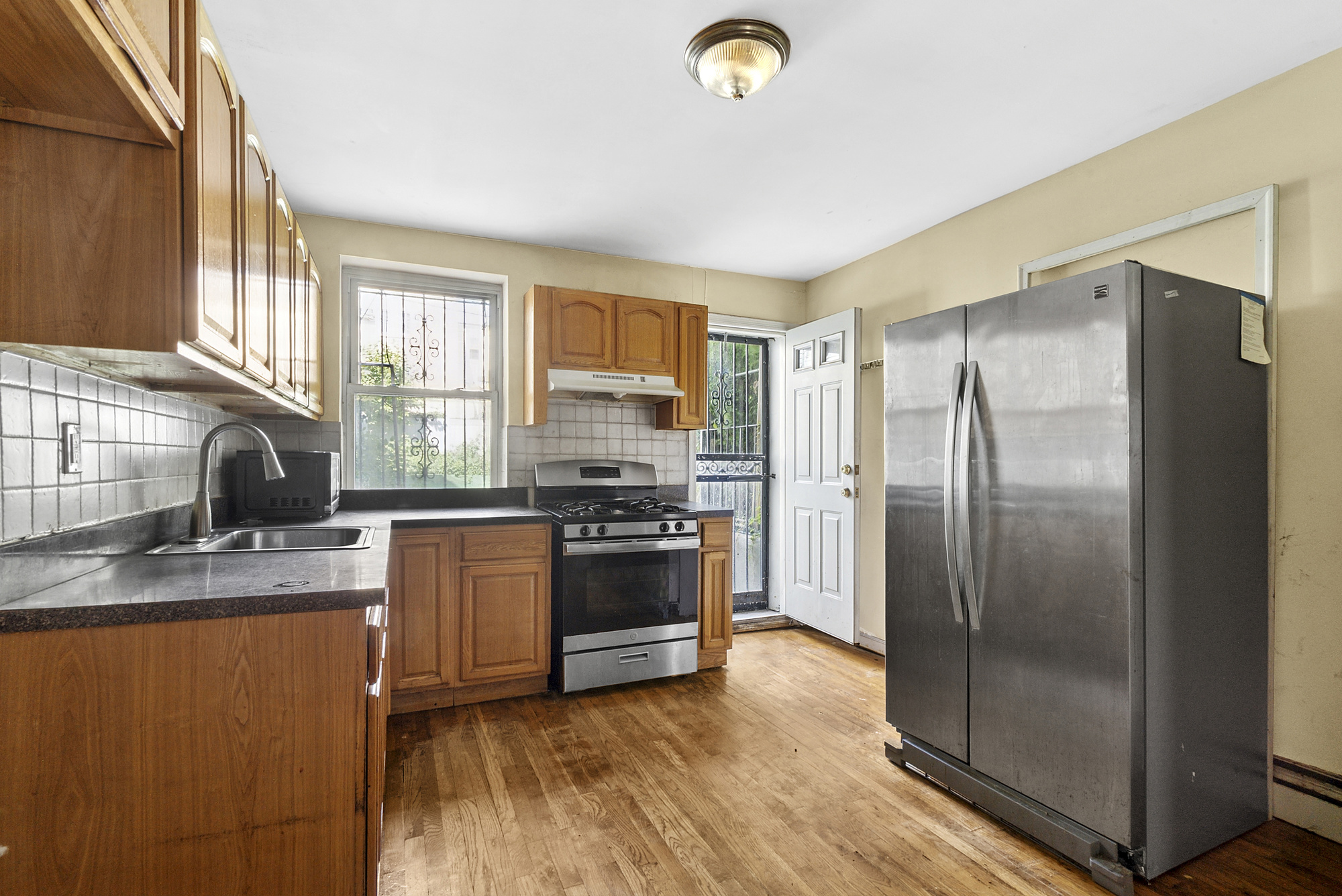 a kitchen with granite countertop a refrigerator stove and sink