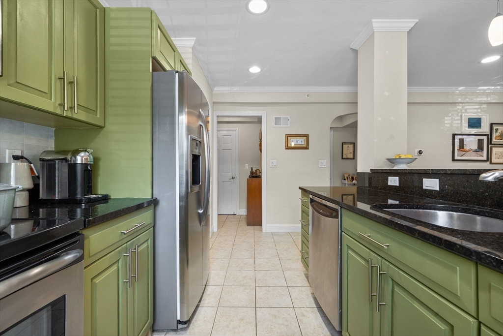 27-29 Commonwealth Avenue, Unit 9 Newton, MA 02467 - Photo 7 of 20 a kitchen with stainless steel appliances granite countertop a sink and cabinets