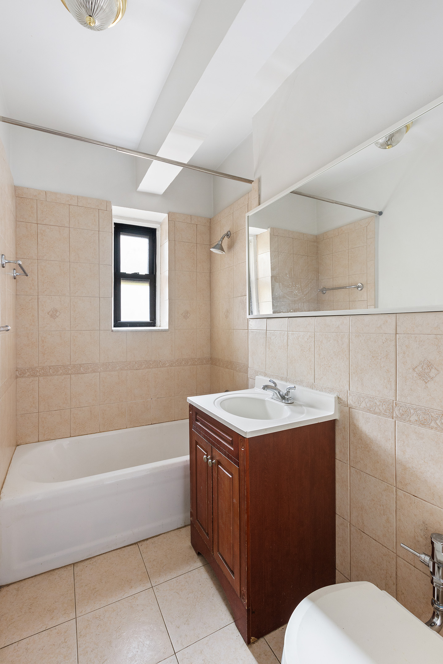 40 Clarkson Avenue, Unit 2L Brooklyn, NY 11226 - Photo 6 of 12 a bathroom with a sink a toilet and bathtub