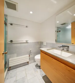 a bathroom with a sink a toilet and a mirror