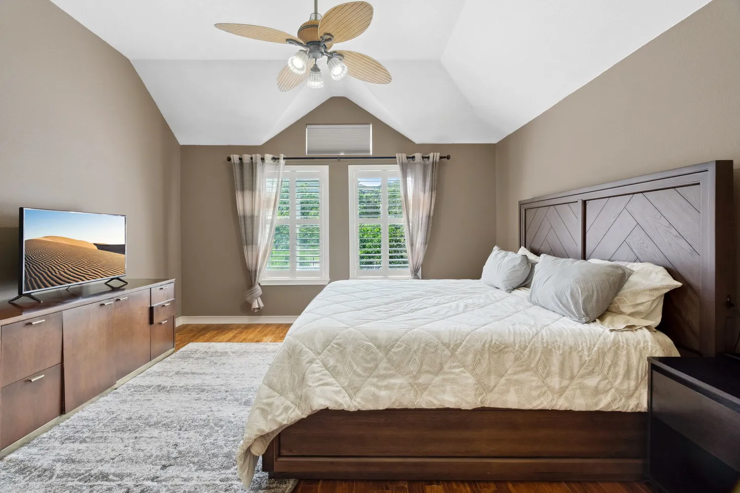 a bedroom with a large bed and a flat screen tv