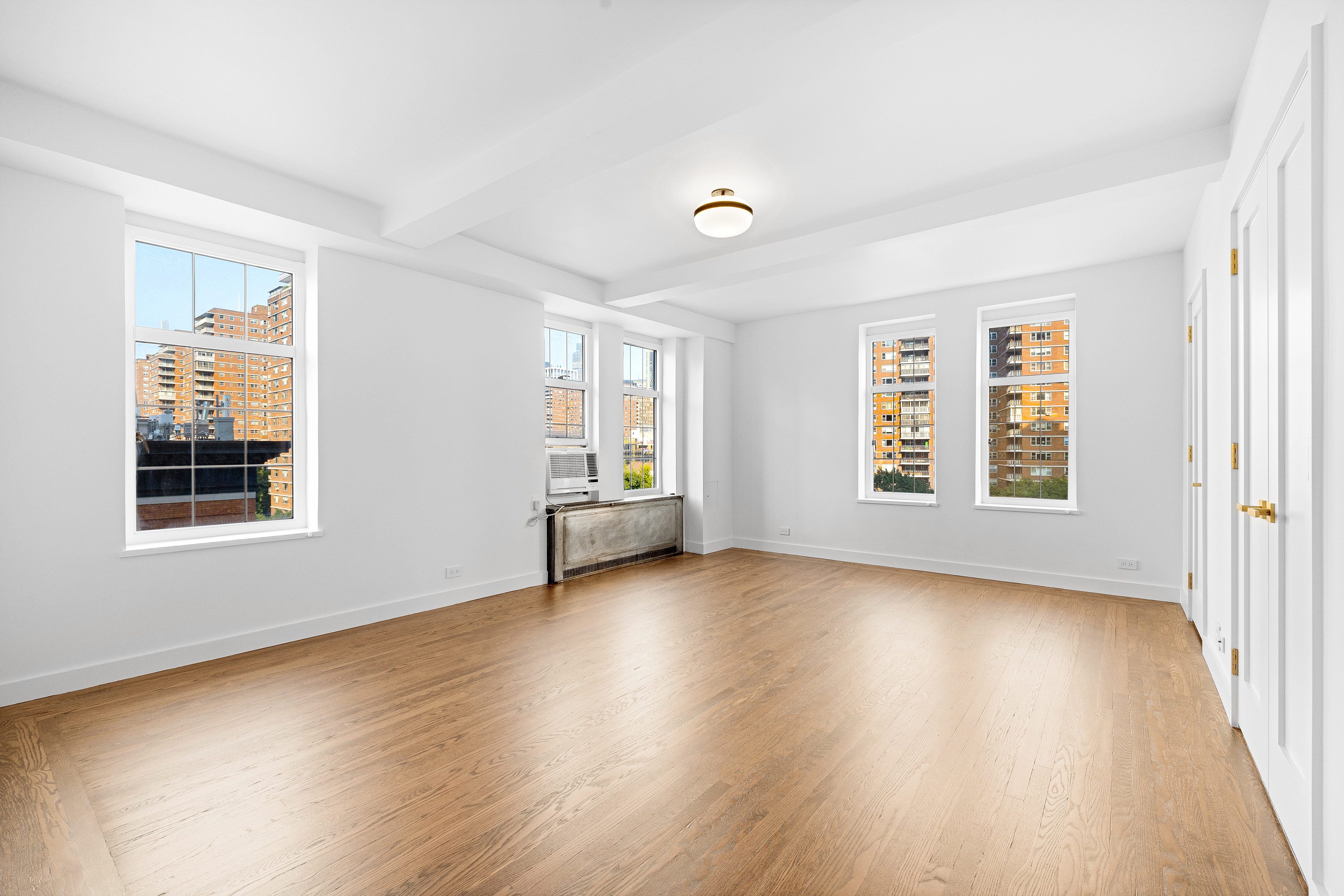 410 West 24th Street, Unit 8F Manhattan, NY 10011 - Photo 6 of 16 a view of an empty room with wooden floor and a window