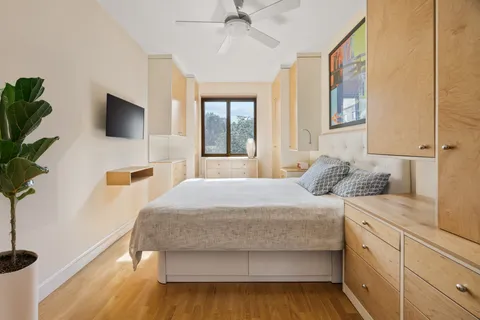 a bedroom with a large bed and a flat tv screen on dresser