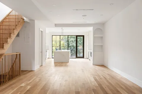 a view of a room with wooden floor and a floor to ceiling window
