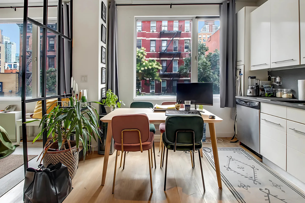 517 West 46th Street, Unit 307 Manhattan, NY 10036 - Photo 2 of 10 a kitchen with a table chairs stove and cabinets