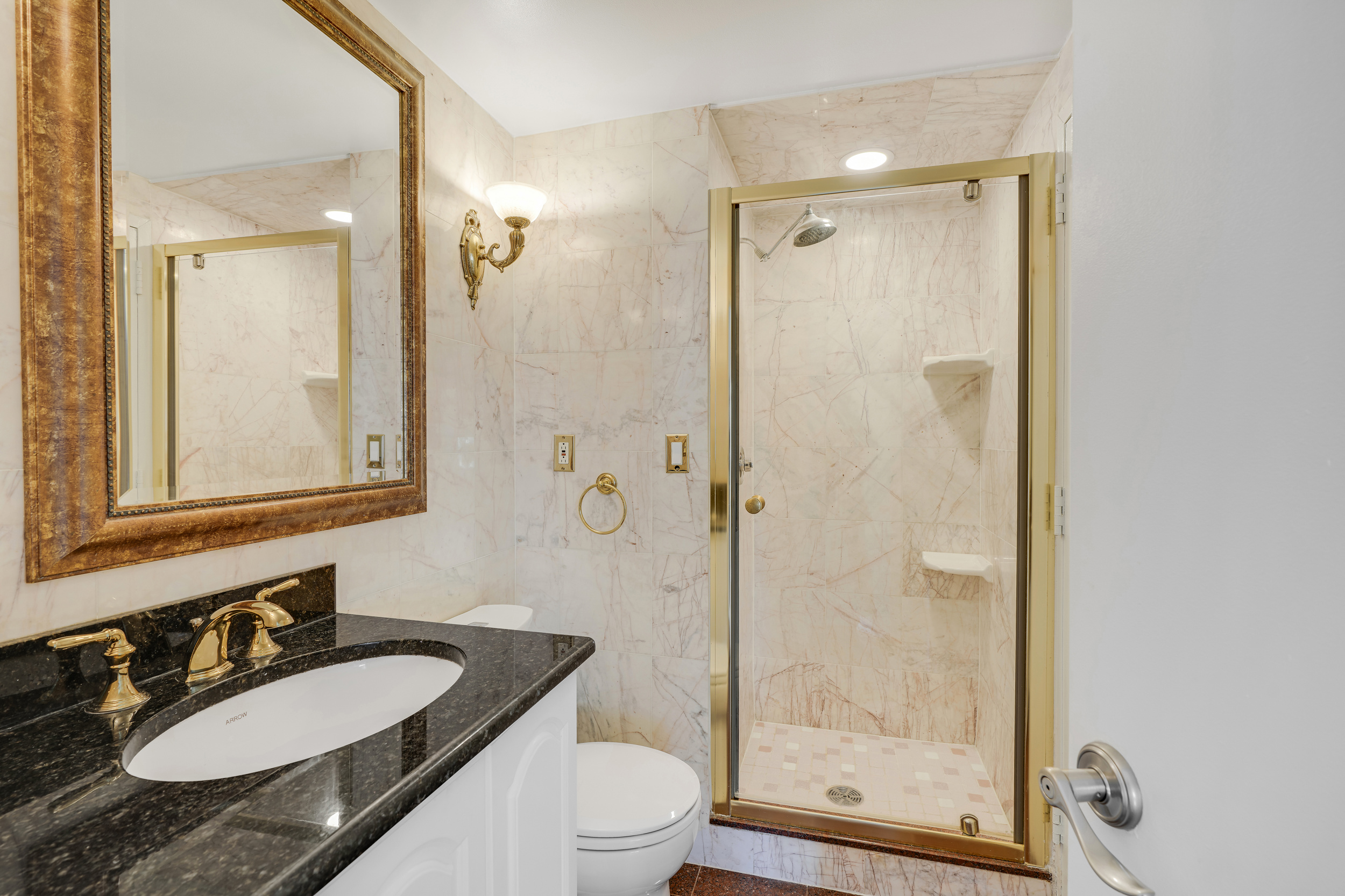 400 East 70th Street, Unit 2402 Manhattan, NY 10021 - Photo 12 of 18 a bathroom with a granite countertop sink toilet a mirror a shower and a mirror