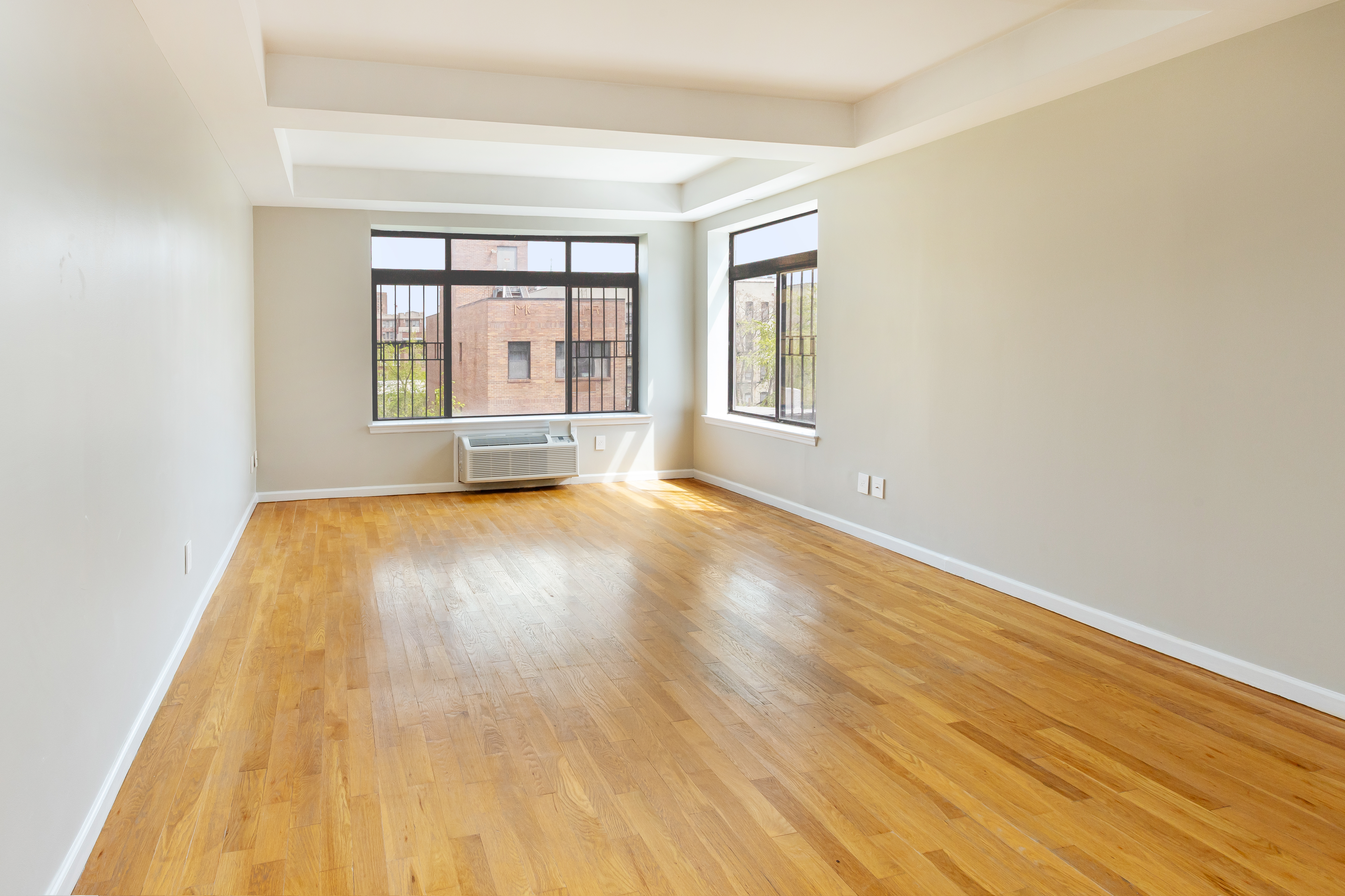416 East 117th Street, Unit 5A Manhattan, NY 10035 - Photo 2 of 16 a view of an empty room with wooden floor and a window
