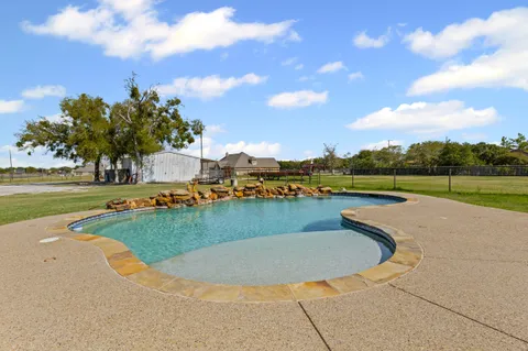 a view of swimming pool with outdoor seating and ocean view