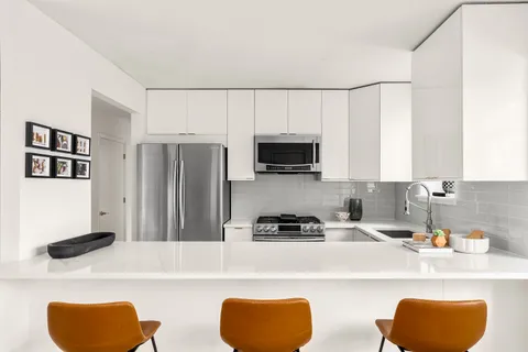 a kitchen with stainless steel appliances granite countertop a sink a stove a refrigerator a counter space and cabinets