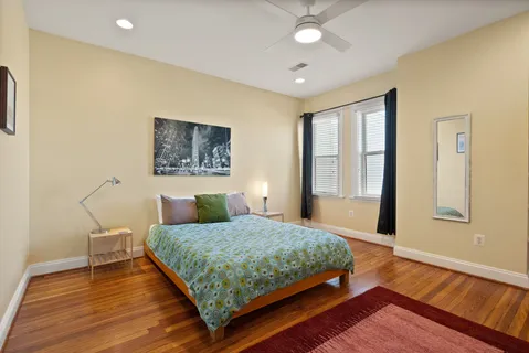 a bedroom with a bed and wooden floor