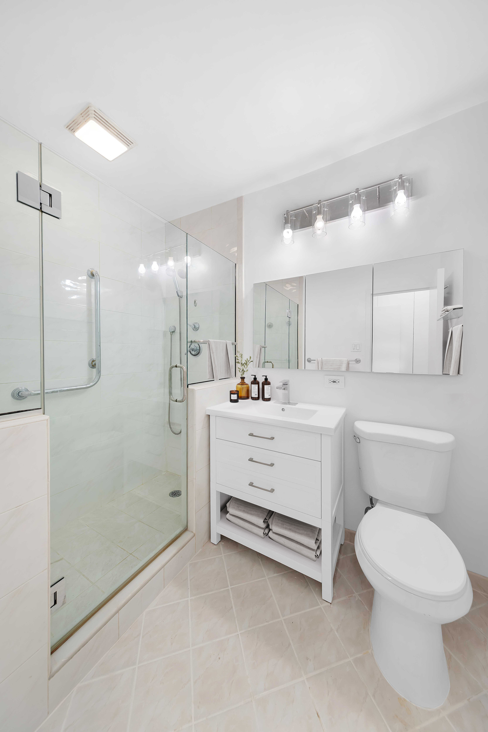 58 West 58th Street, Unit 21C Manhattan, NY 10019 - Photo 8 of 12 a bathroom with a sink a toilet and shower