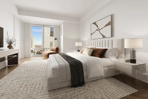 a bedroom with a large bed and a chandelier