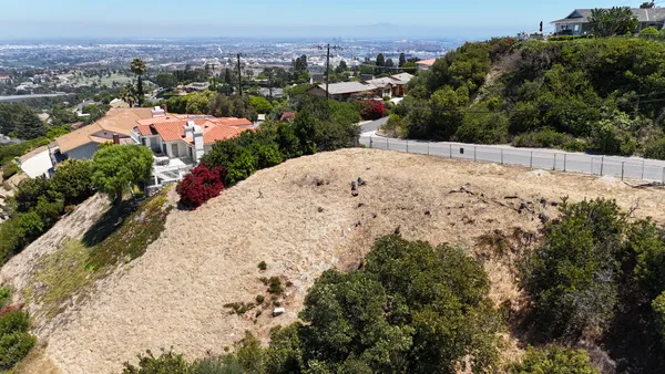 an aerial view of a house with a yard and mountain view in back