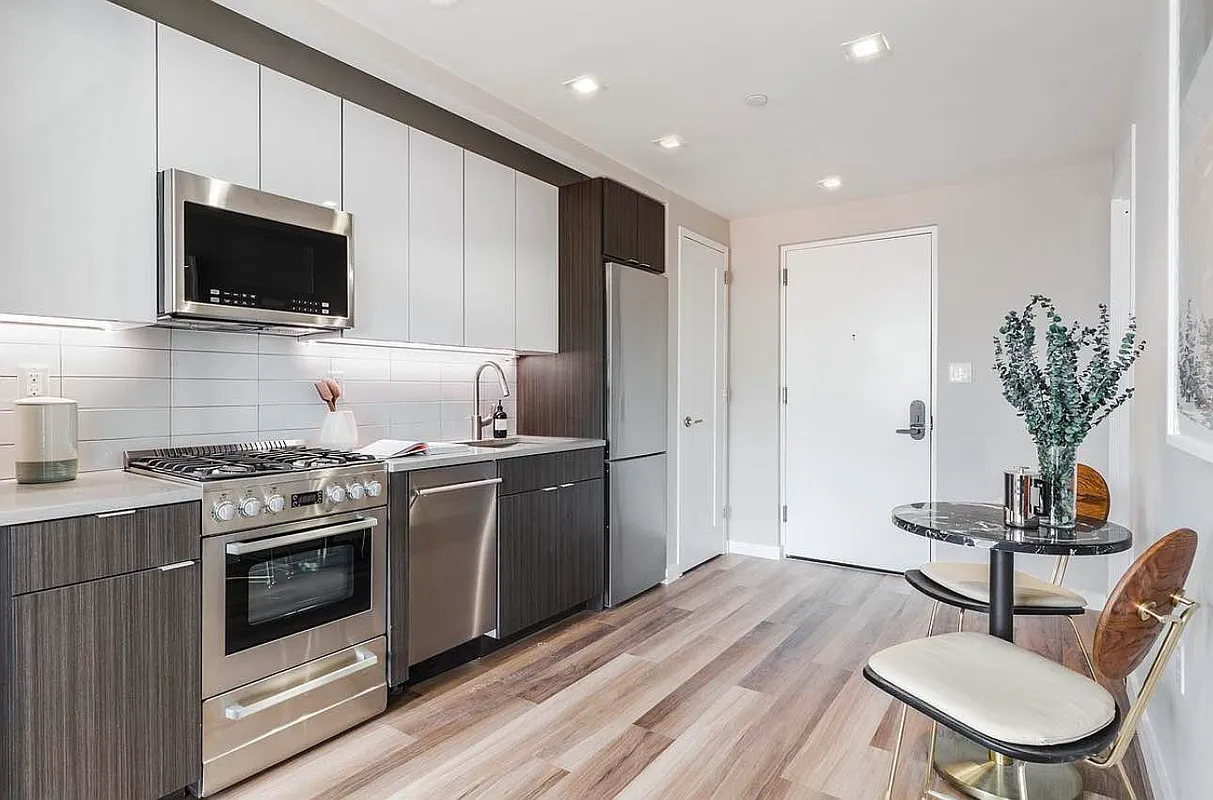 2415 Church Avenue, Unit 204 Brooklyn, NY 11226 - Photo 3 of 5 a kitchen with stainless steel appliances a stove a microwave a refrigerator a stove a microwave oven with a dining table and chairs