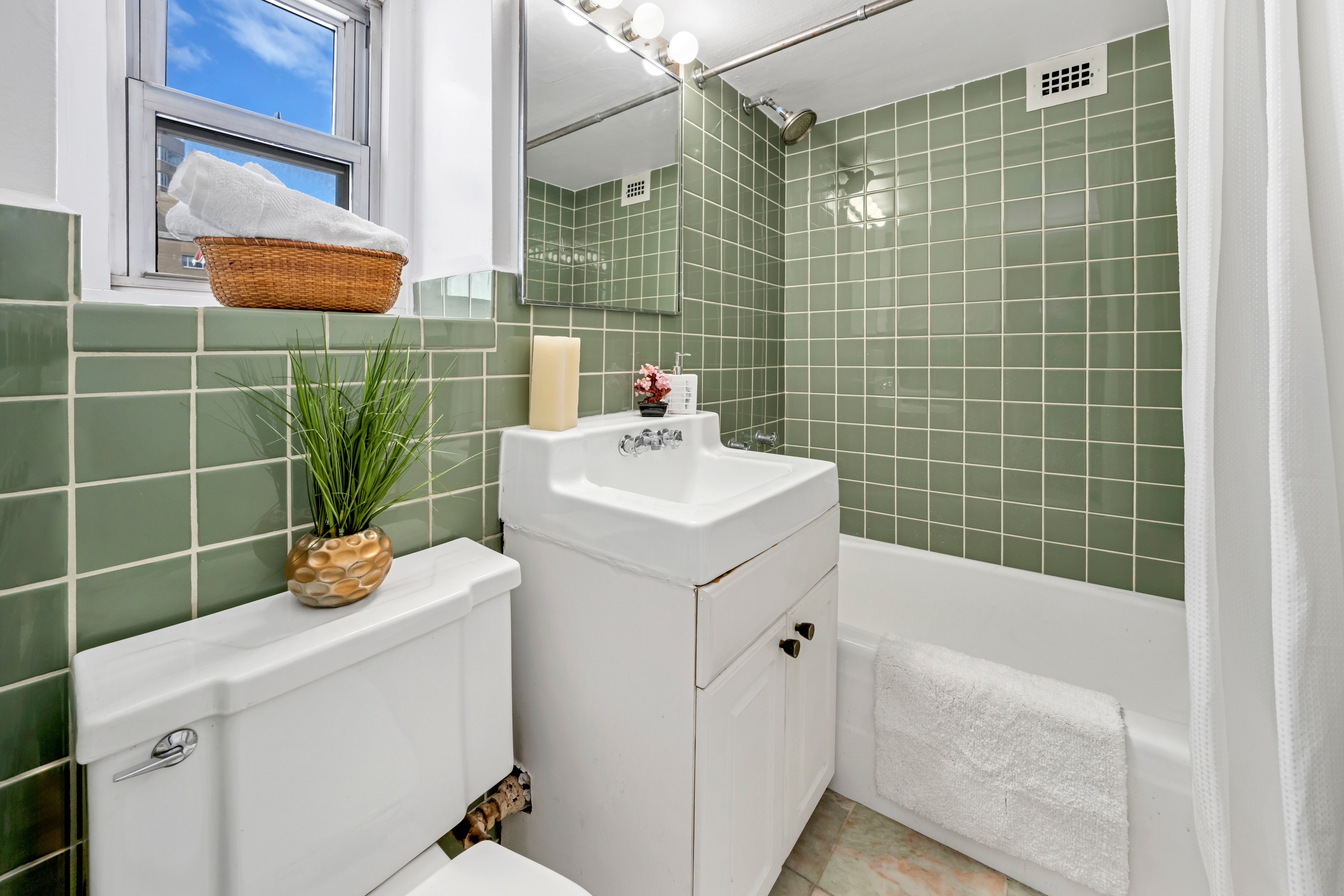 210 East 63rd Street, Unit 11F Manhattan, NY 10065 - Photo 8 of 14 a bathroom with a sink a toilet and shower