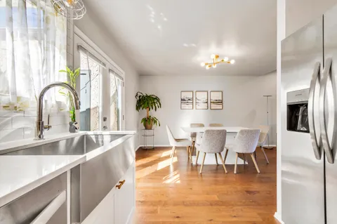 a view of a dining room with furniture a chandelier and wooden floor
