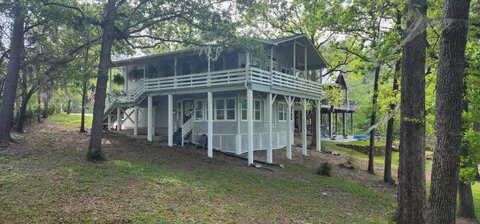 a view of a house with a yard and large tree
