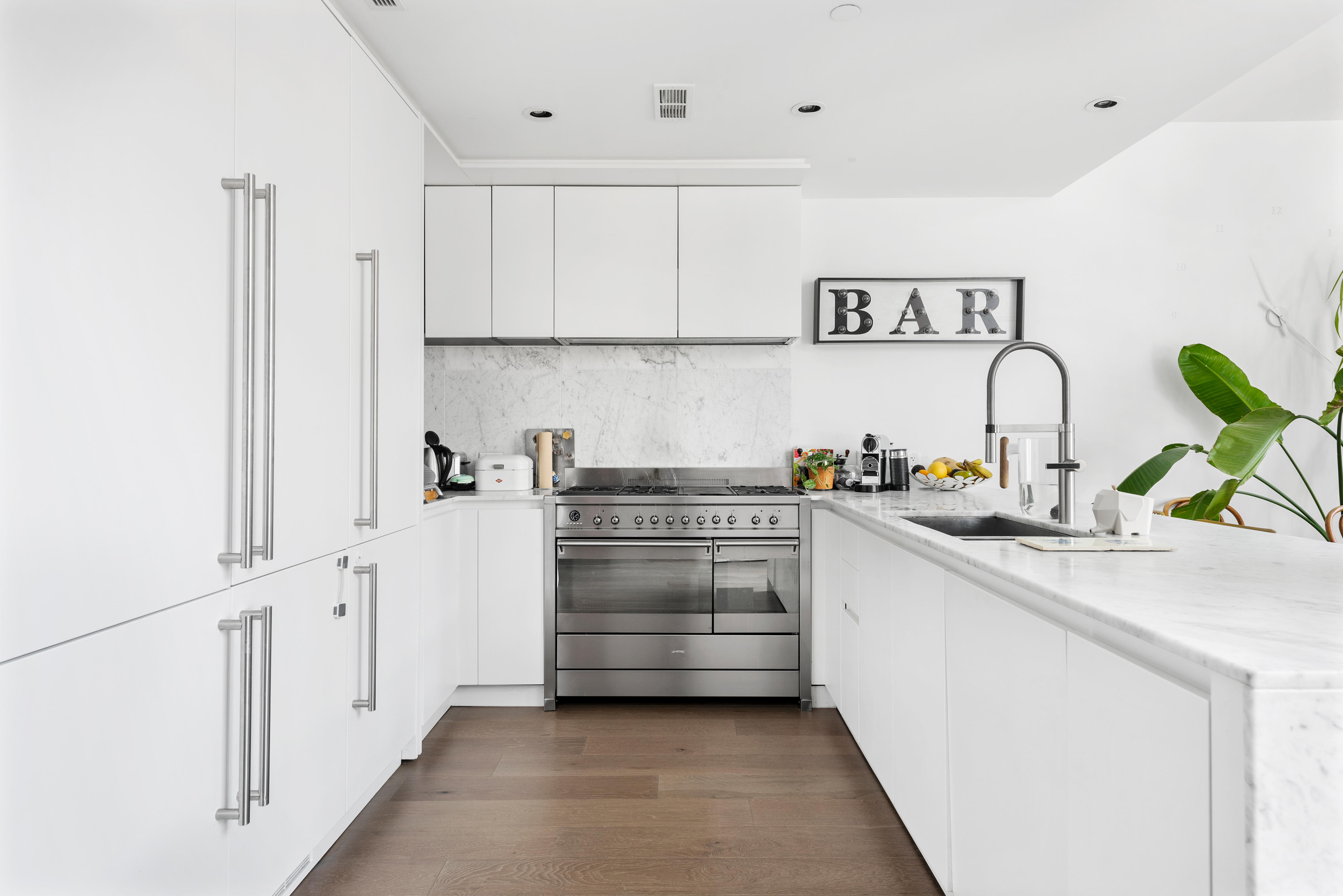429 Kent Avenue, Unit D726 Brooklyn, NY 11249 - Photo 4 of 21 a kitchen with granite countertop white cabinets and white appliances