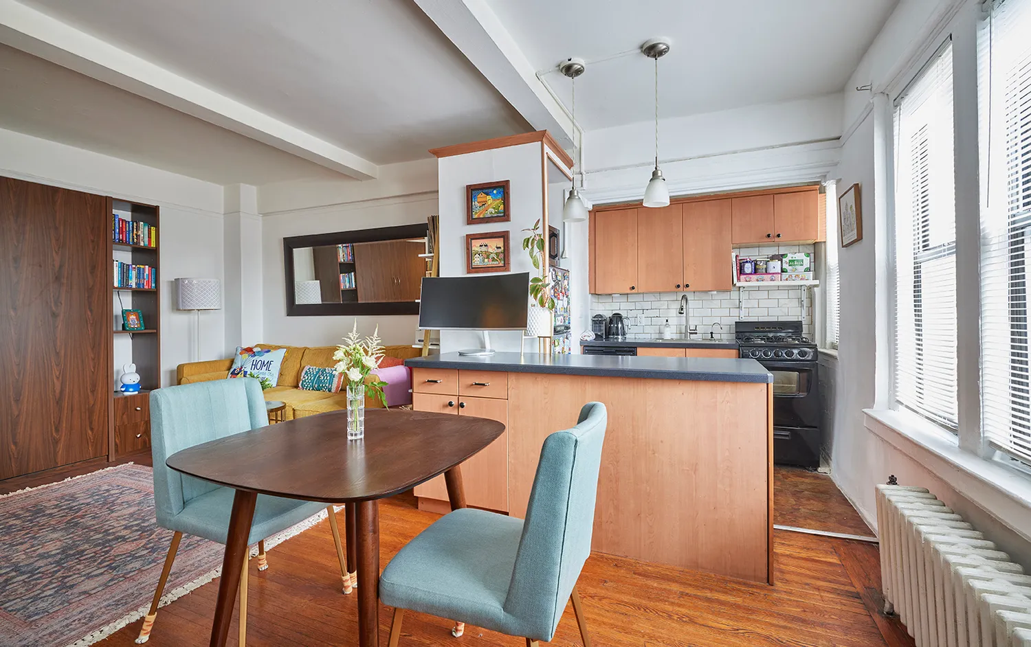 a kitchen with stainless steel appliances granite countertop a stove top oven a refrigerator a dining table and chairs with wooden floor