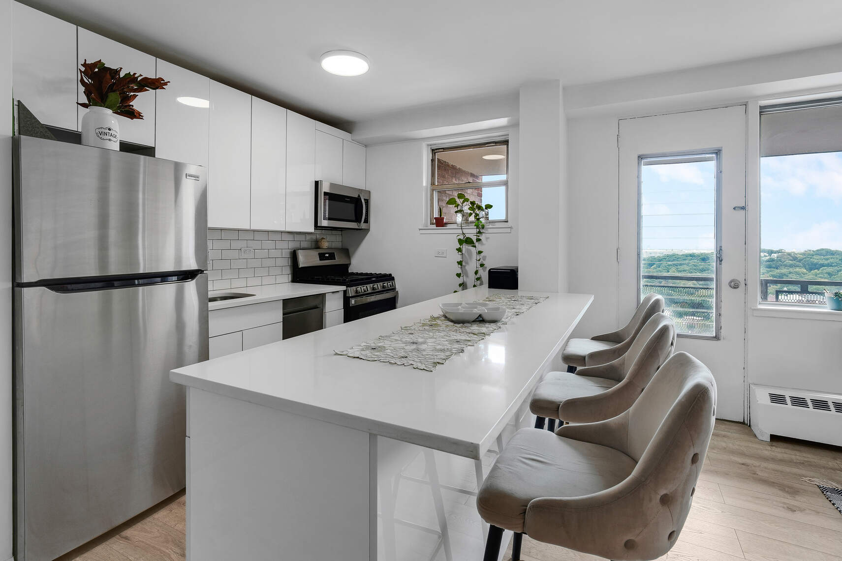5800 Arlington Avenue, Unit 17D Bronx, NY 10471 - Photo 2 of 14 a kitchen with stainless steel appliances granite countertop a refrigerator a stove a sink a dining table and chairs with wooden floor