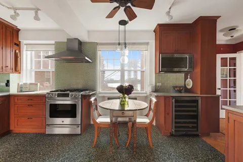 a kitchen with stainless steel appliances a stove a table and chairs