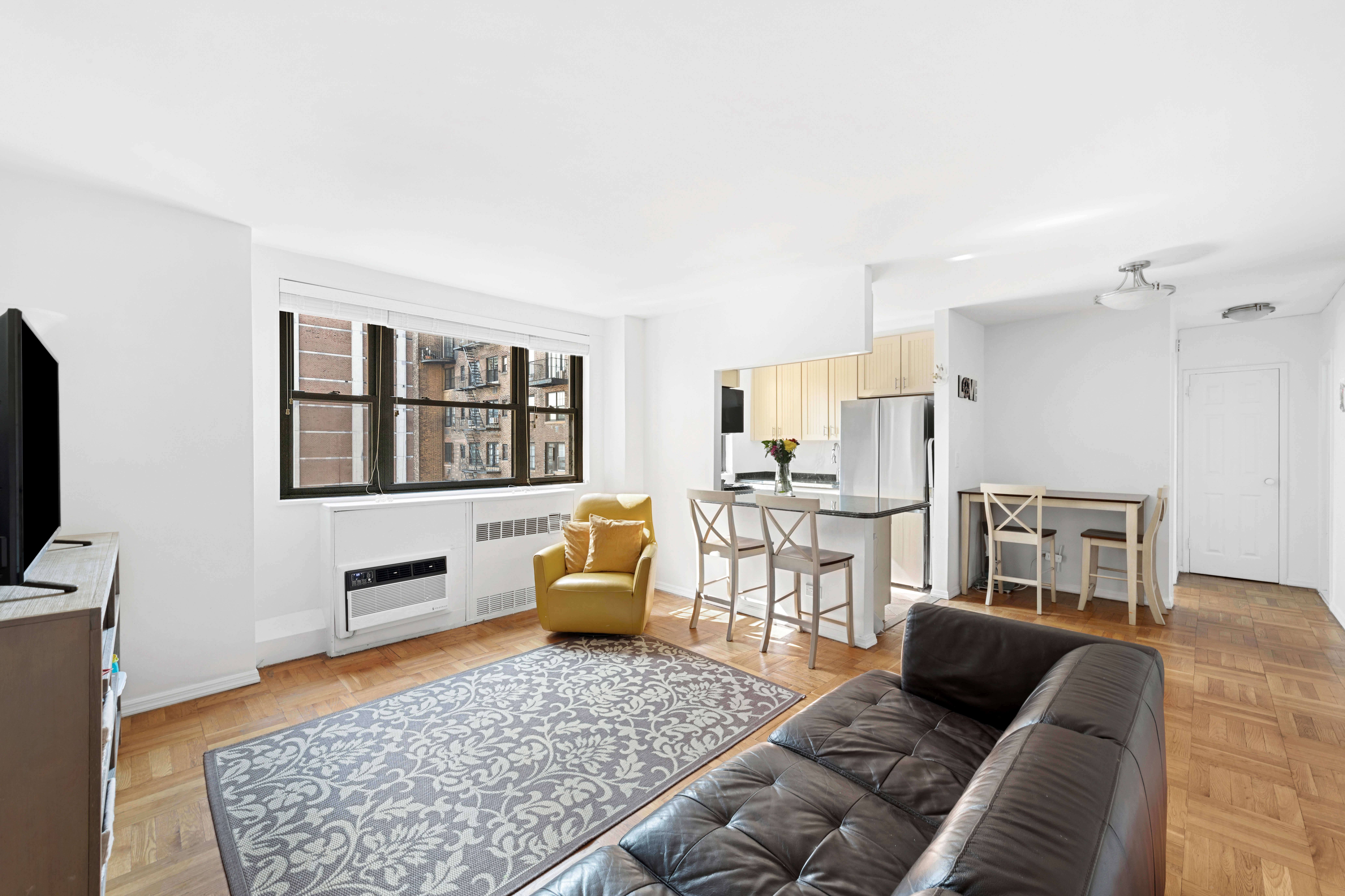 315 East 72nd Street, Unit 15M Manhattan, NY 10021 - Photo 5 of 18 a living room with furniture and a flat screen tv
