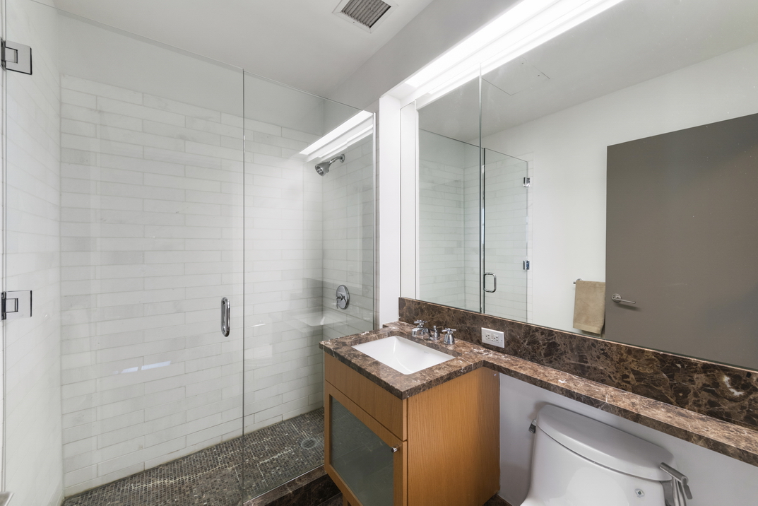 207 East 57th Street, Unit 34A Manhattan, NY 10022 - Photo 14 of 22 a bathroom with a granite countertop sink and a mirror