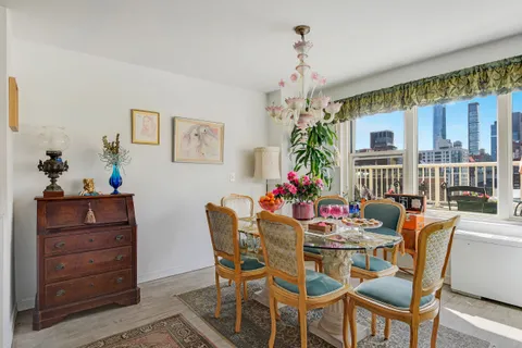 a dining room with furniture a chandelier and window