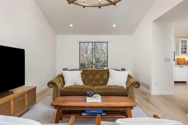 a living room with furniture a flat screen tv and a window