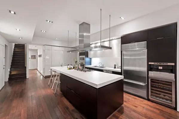 a kitchen with kitchen island a sink appliances and wooden floor