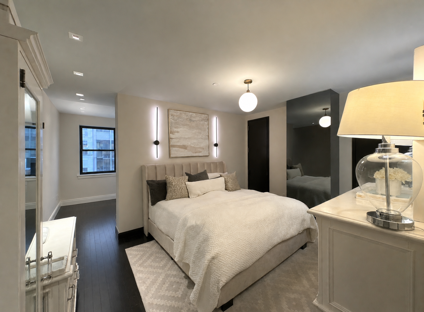 20 Pine Street, Unit 1415 Manhattan, NY 10005 - Photo 3 of 8 a large bedroom with a bed and a large mirror on the dresser