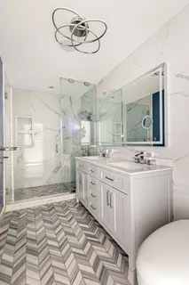 a bathroom with a sink a toilet a mirror and shower