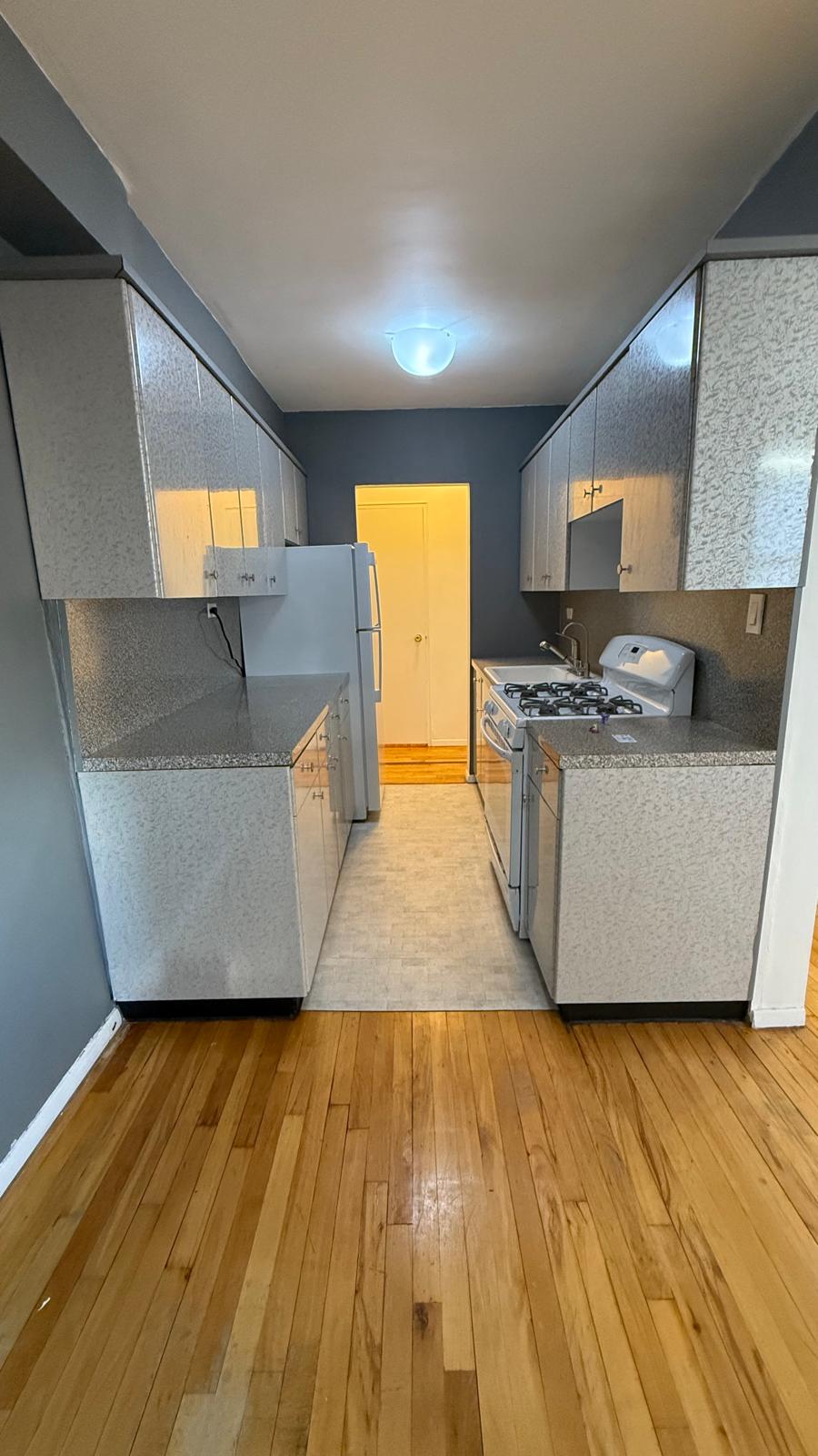 2665 Homecrest Avenue, Unit 4ZC Brooklyn, NY 11235 - Photo 6 of 9 a living room with stainless steel appliances wooden floors and kitchen view