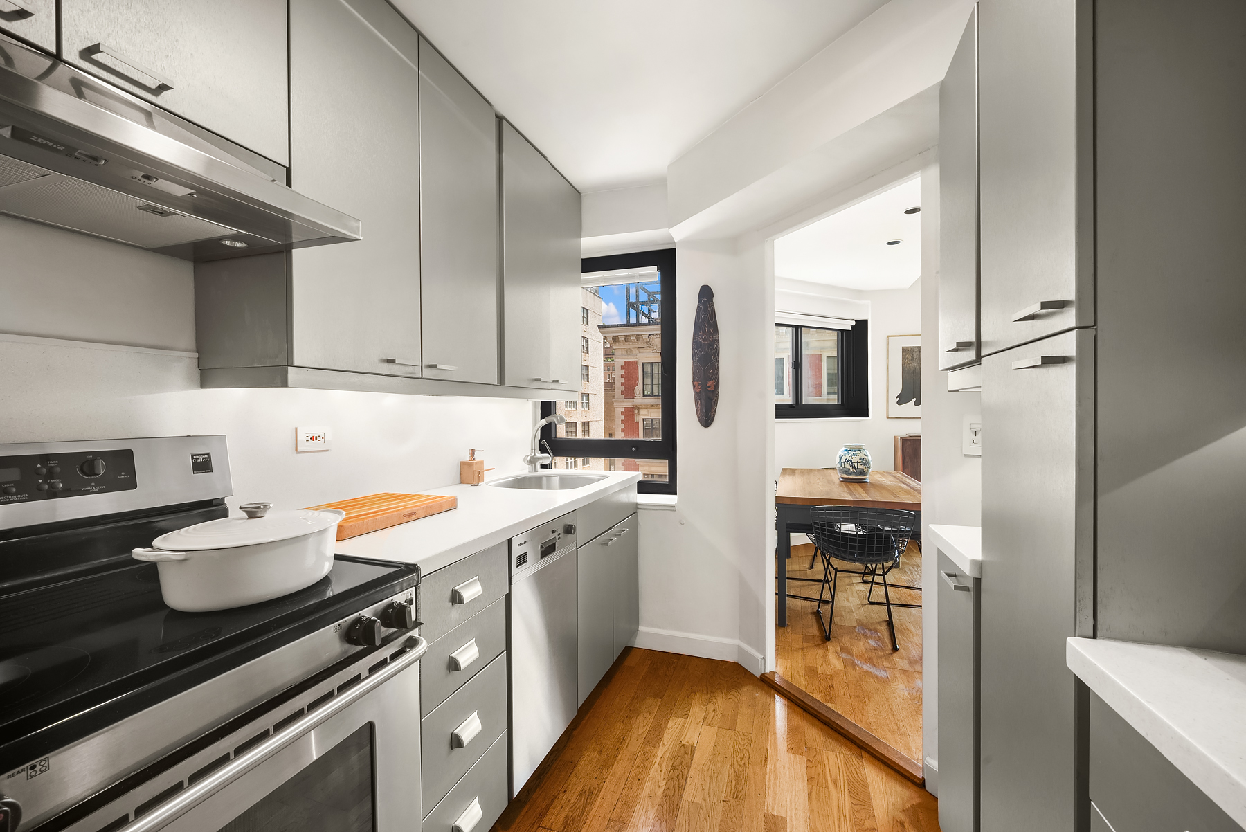 25 East 83rd Street, Unit 9B Manhattan, NY 10028 - Photo 3 of 8 a kitchen with stainless steel appliances sink stove refrigerator and cabinets