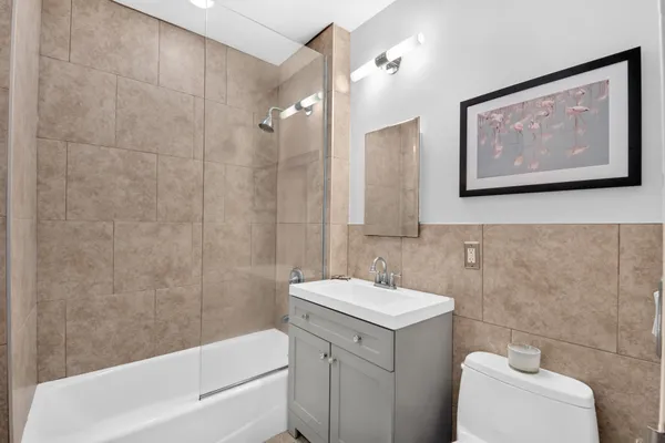 a bathroom with a sink mirror vanity and bathtub