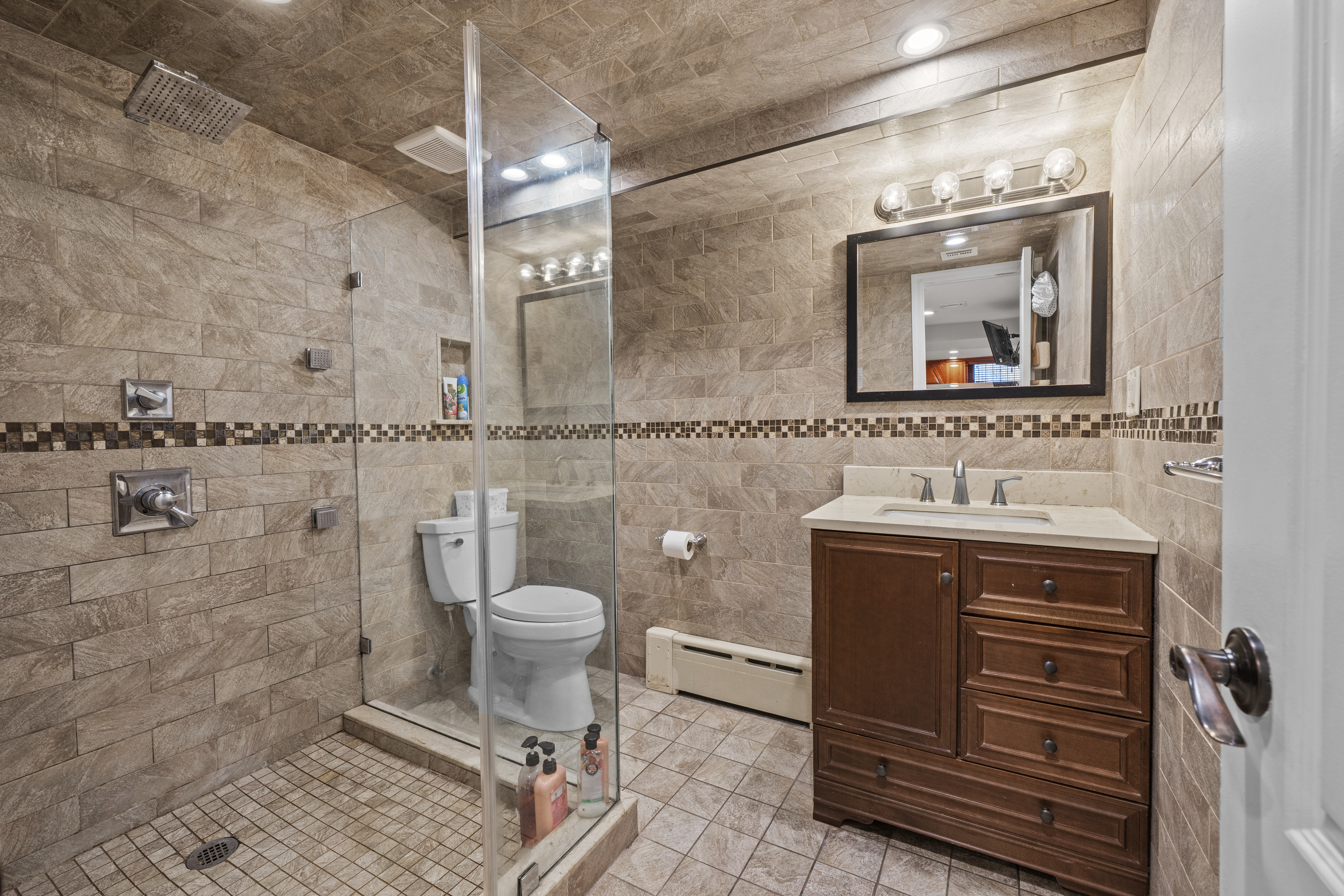 2253 East 64th Street Brooklyn, NY 11234 - Photo 31 of 45 a bathroom with a sink toilet and mirror