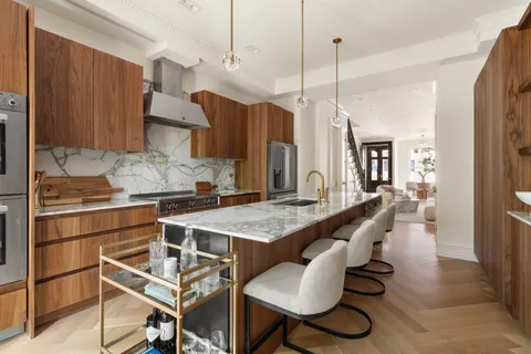 a kitchen with a table chairs sink and cabinets