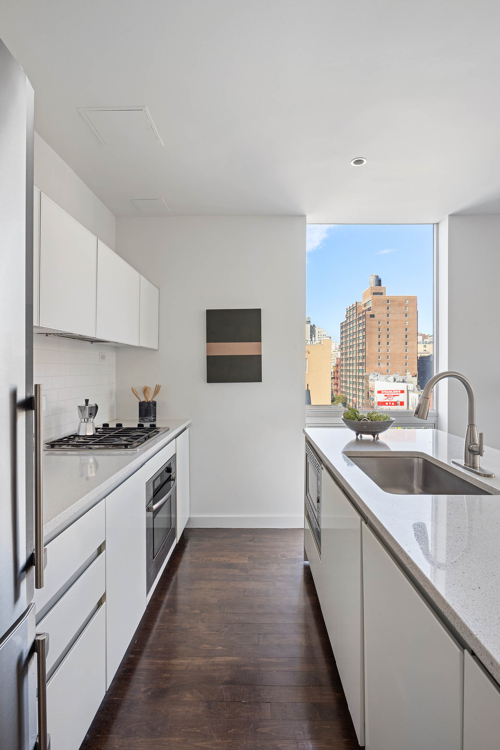 425 East 13th Street, Unit PHFG Manhattan, NY 10009 - Photo 7 of 31 a kitchen with a sink stove top oven and cabinets