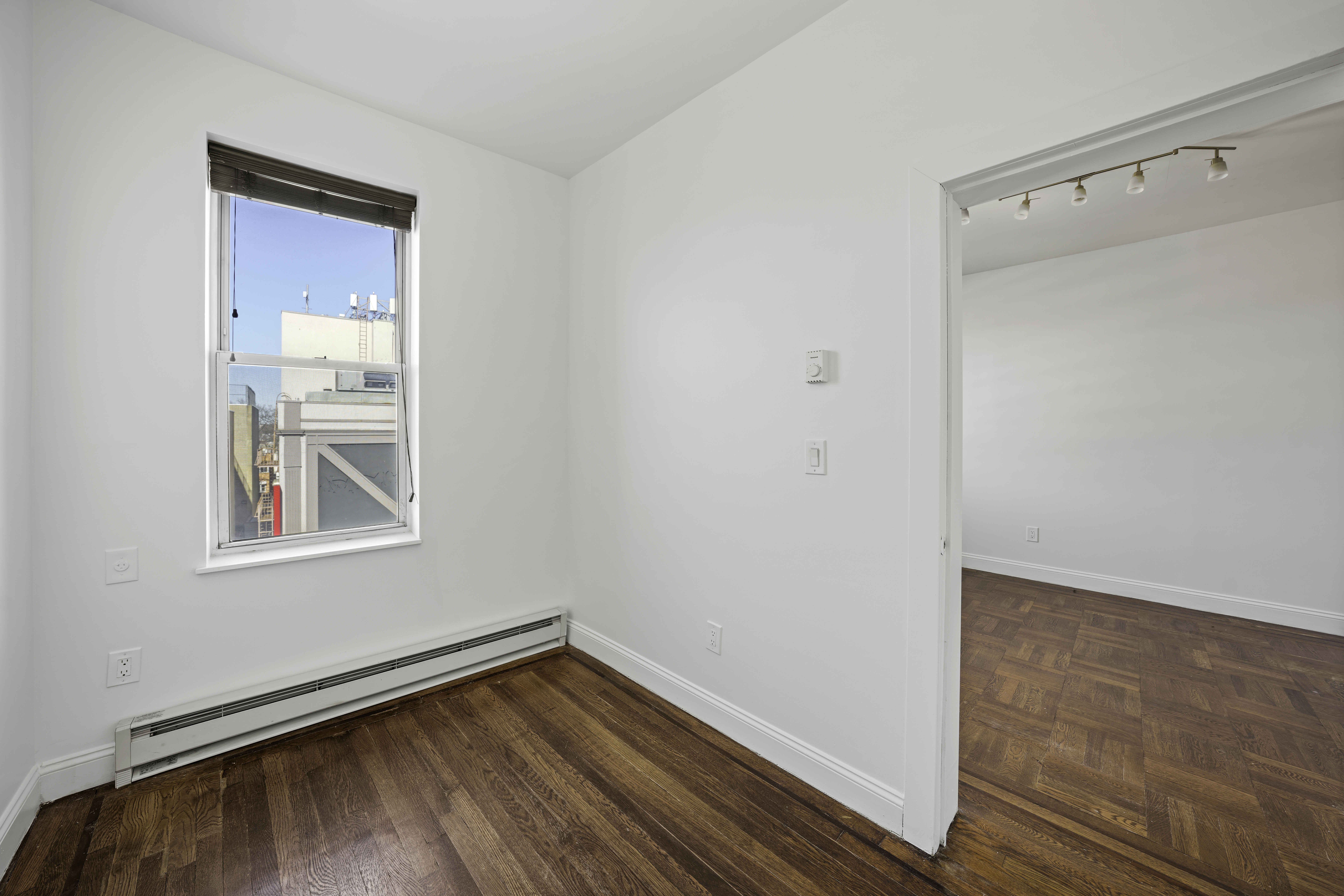 514 86th Street, Unit 4 Brooklyn, NY 11209 - Photo 13 of 19 a view of an empty room with wooden floor and a window