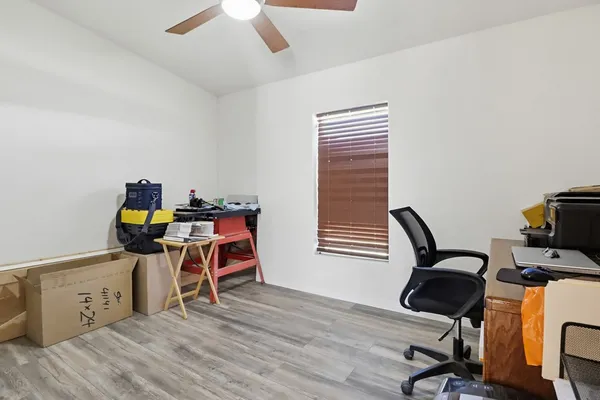 a view of a workspace with furniture and a window
