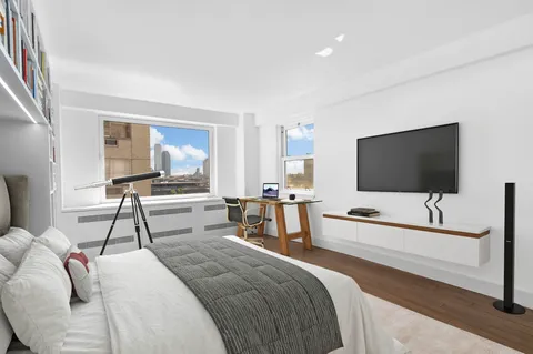 a bedroom with a bed and a flat tv screen on the dresser