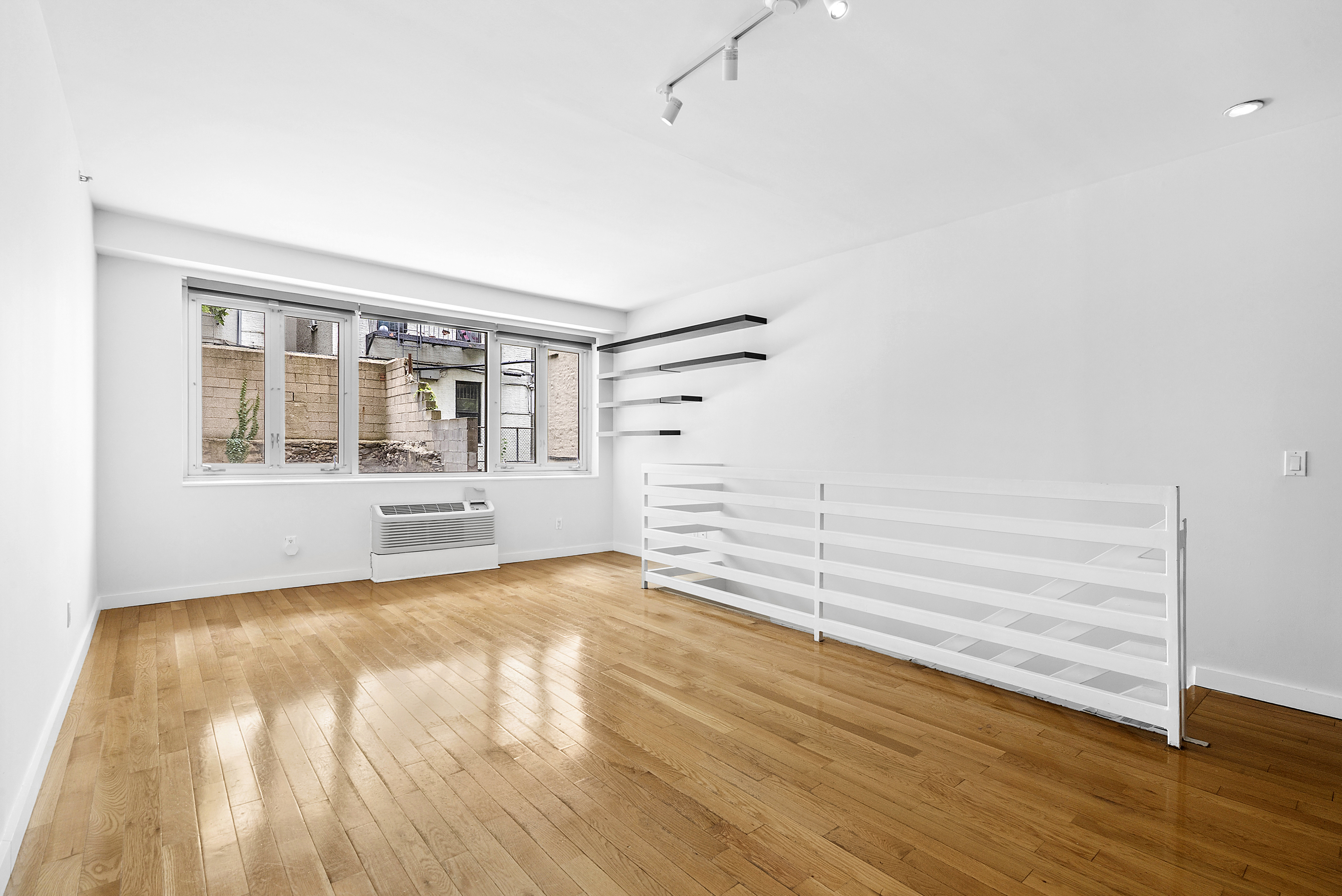450 East 117th Street, Unit 1A Manhattan, NY 10035 - Photo 4 of 10 a view of an empty room with wooden floor and a window