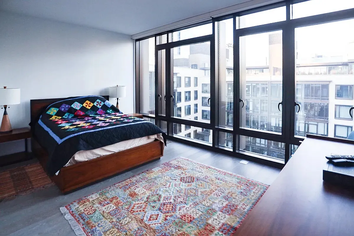 a bedroom with furniture and a large window