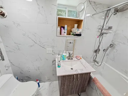 a bathroom with a sink vanity mirror and toilet