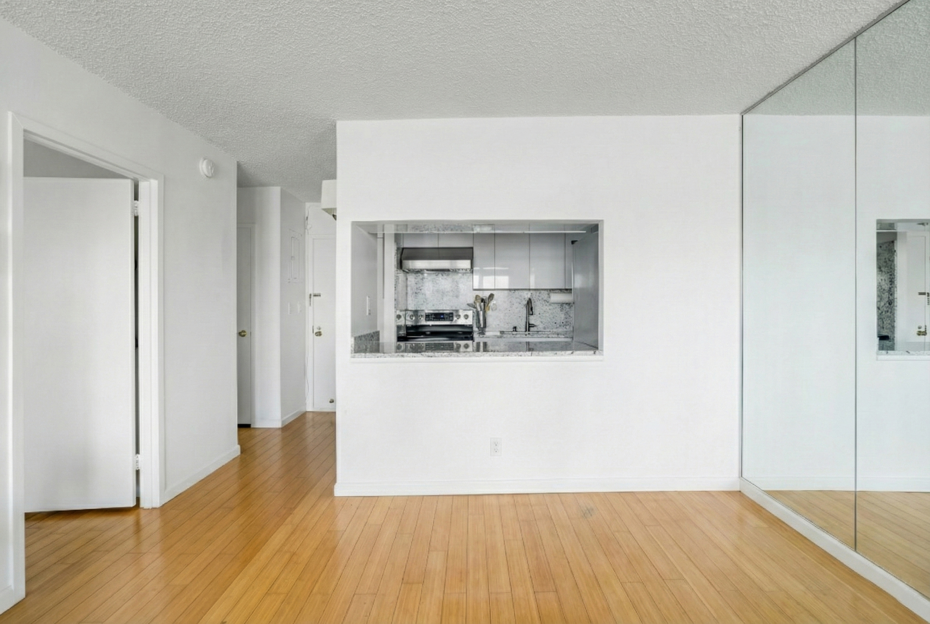2540 Shore Boulevard, Unit 4S Queens, NY 11102 - Photo 10 of 31 a view of a kitchen with wooden floor and a refrigerator