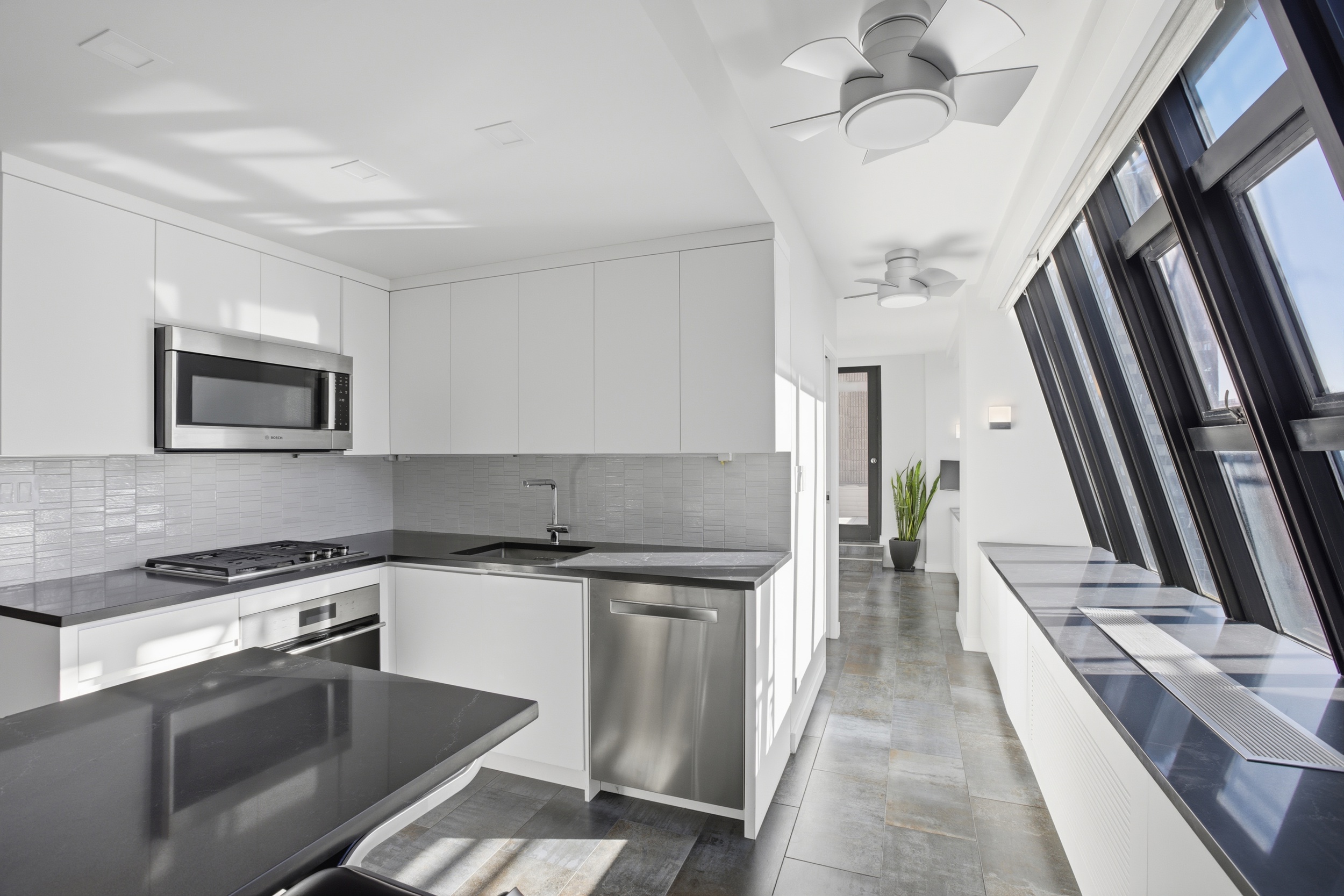 309 East 49th Street, Unit 21A Manhattan, NY 10017 - Photo 9 of 18 a kitchen with granite countertop a sink appliances and cabinets