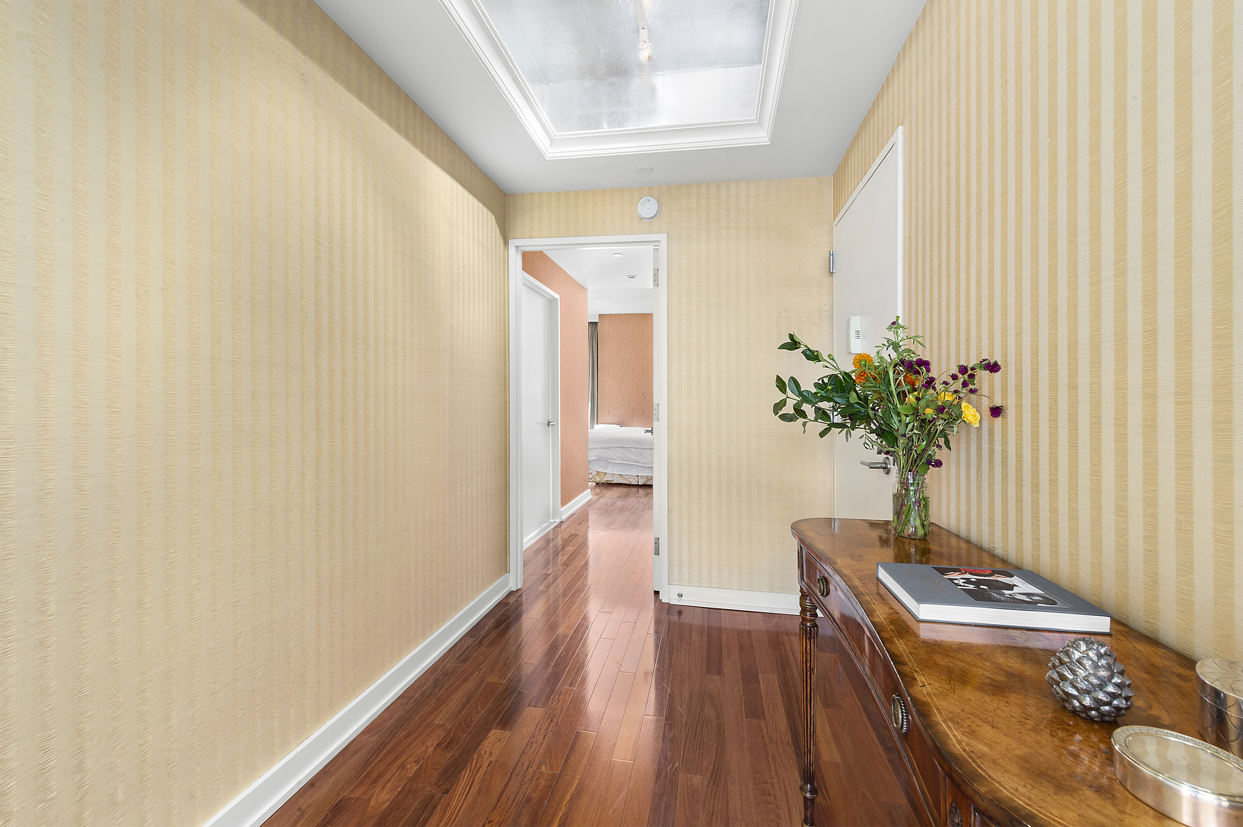 60 East 55th Street, Unit 40B Manhattan, NY 10022 - Photo 4 of 12 a view of a hallway with wooden floor and a potted plant