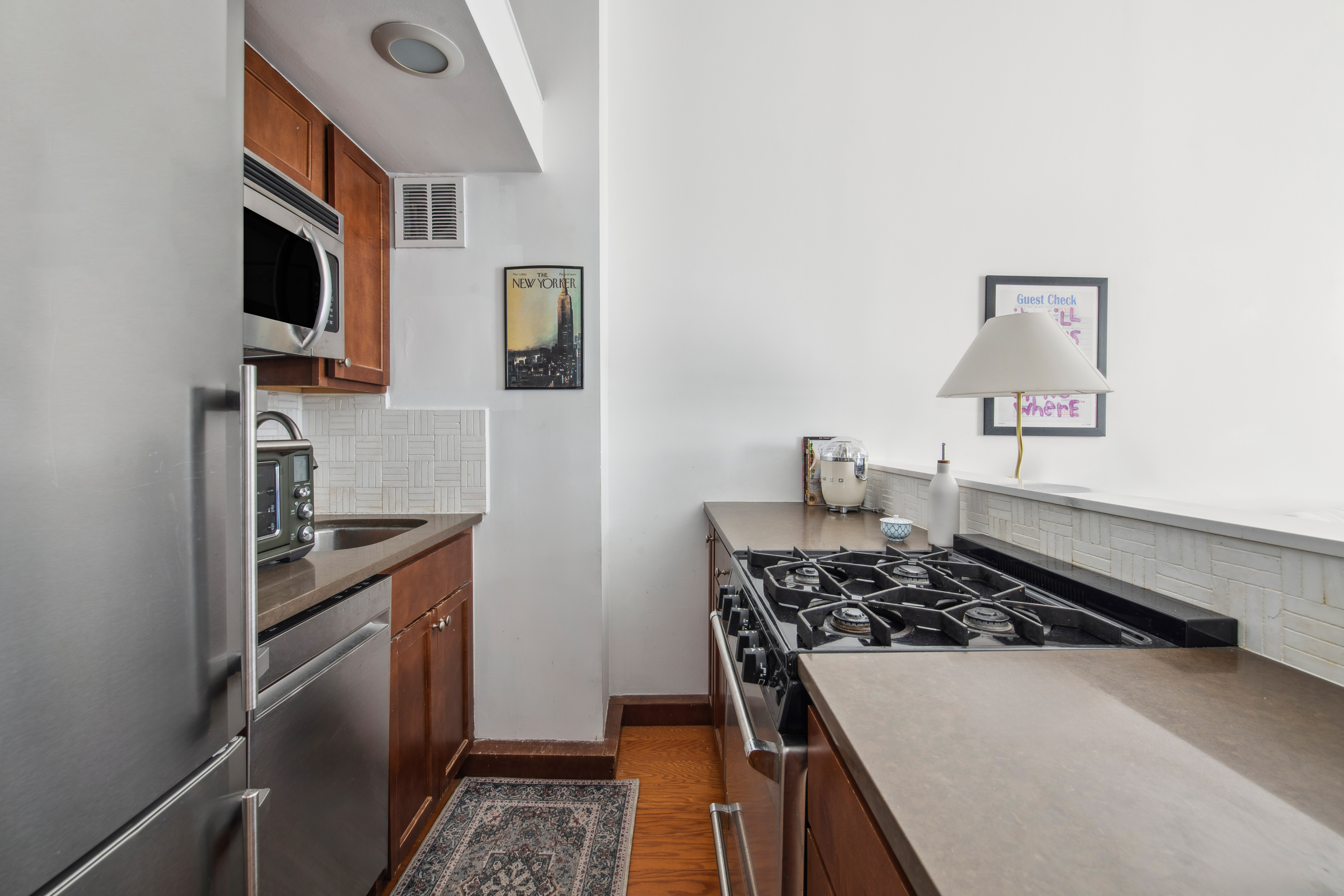350 East 62nd Street, Unit 3J Manhattan, NY 10065 - Photo 3 of 9 a kitchen with a stove and a microwave
