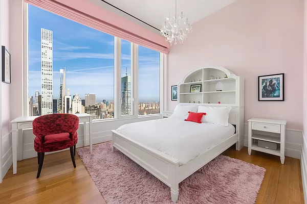 252 East 57th Street, Unit 62B Manhattan, NY 10022 - Photo 10 of 15 a room with a bed a chandelier and a dresser